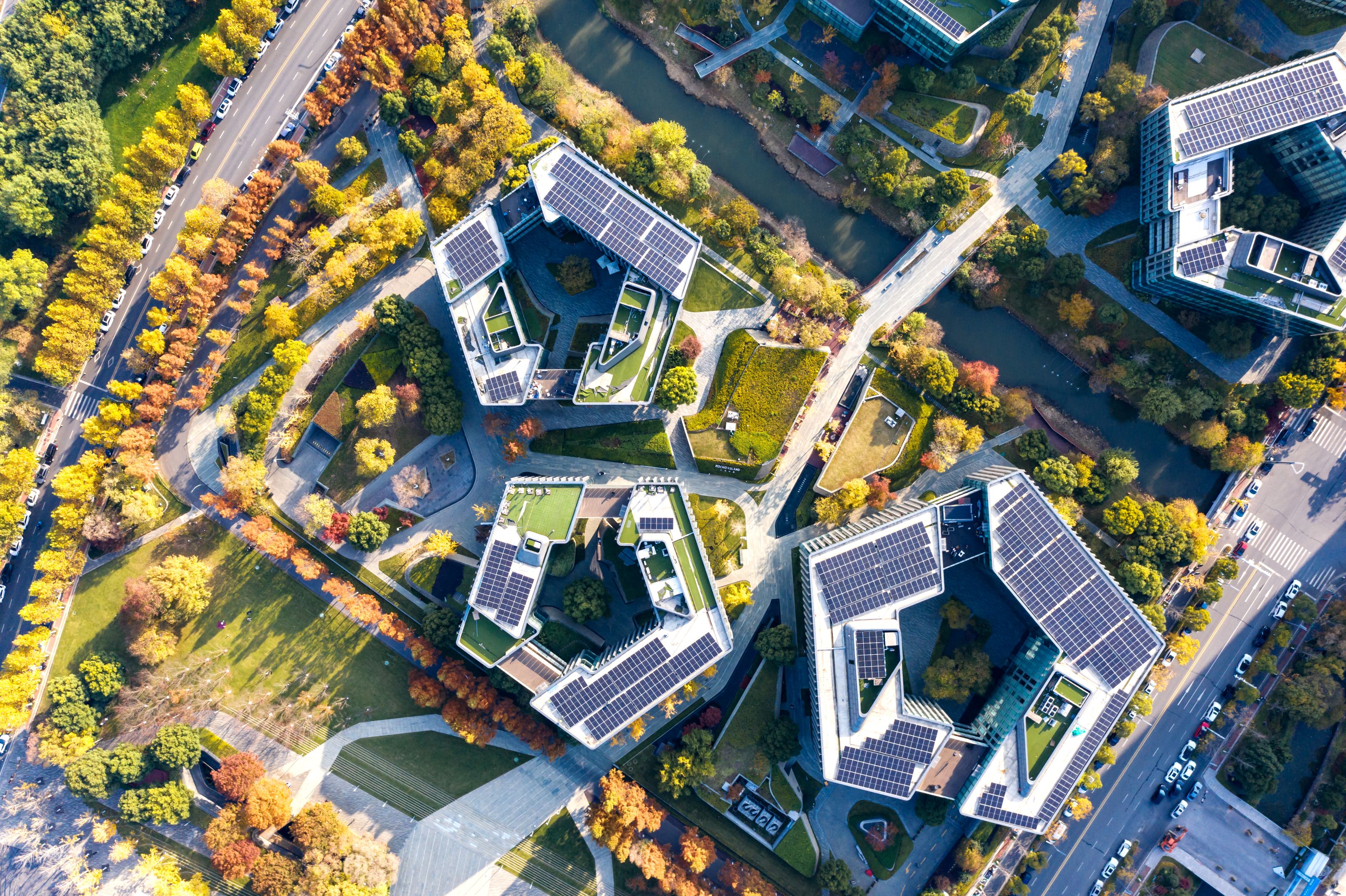 Trois bâtiments vu du ciel entourés de verdure